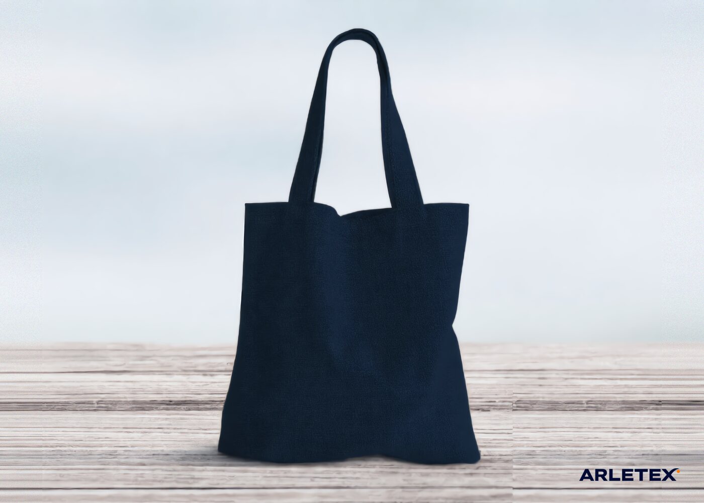 Tote bag de loneta azul marino de pie, con asas del mismo tejido
