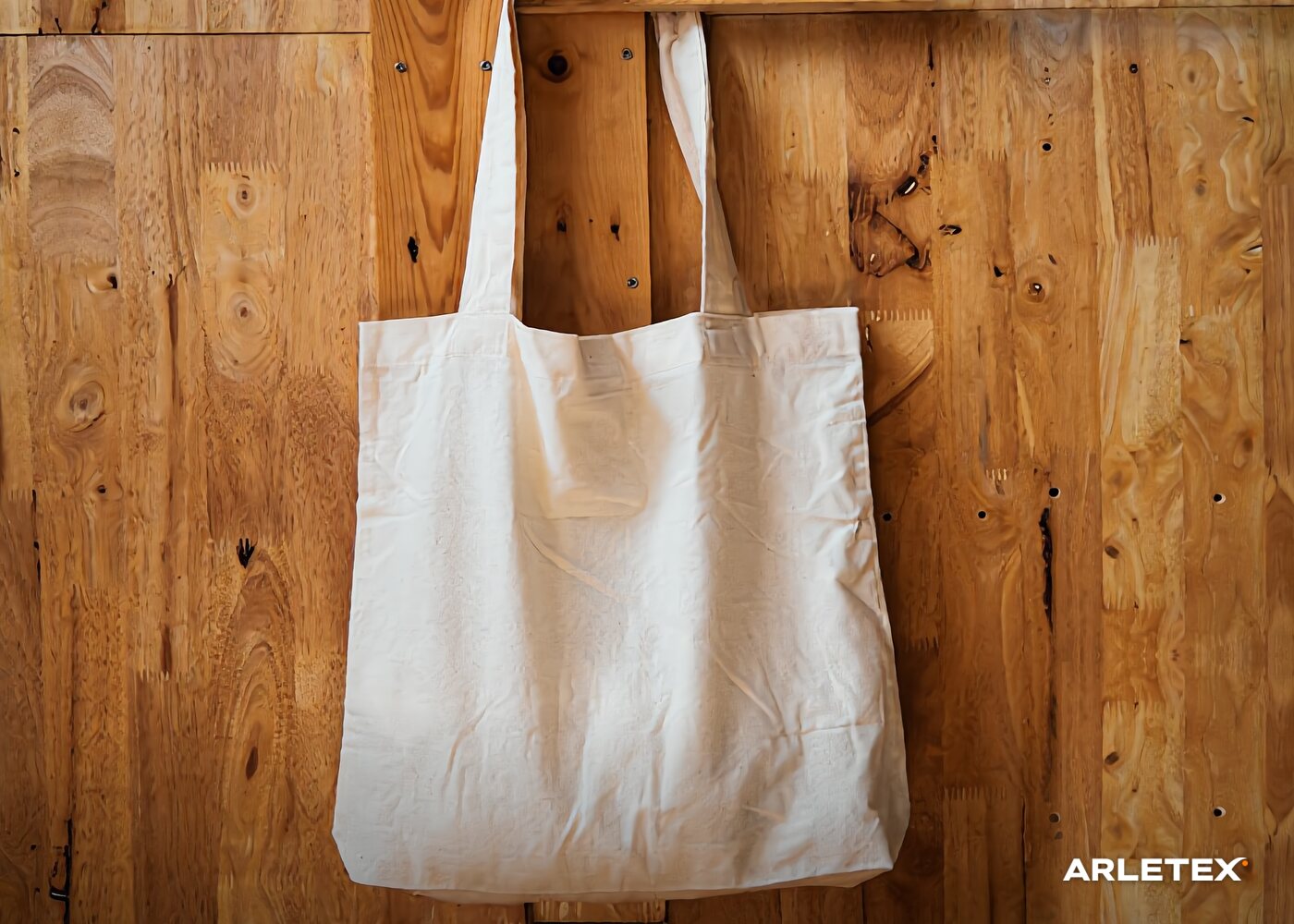 Tote bag de manta colgada sobre una pared de madera